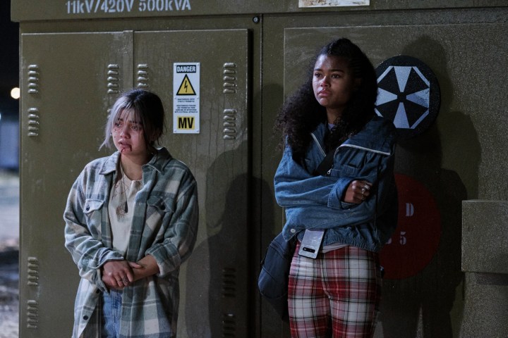 Siena Agudong and Tamara Smart stand in front of lockers in a scene from the Resident Evil series.