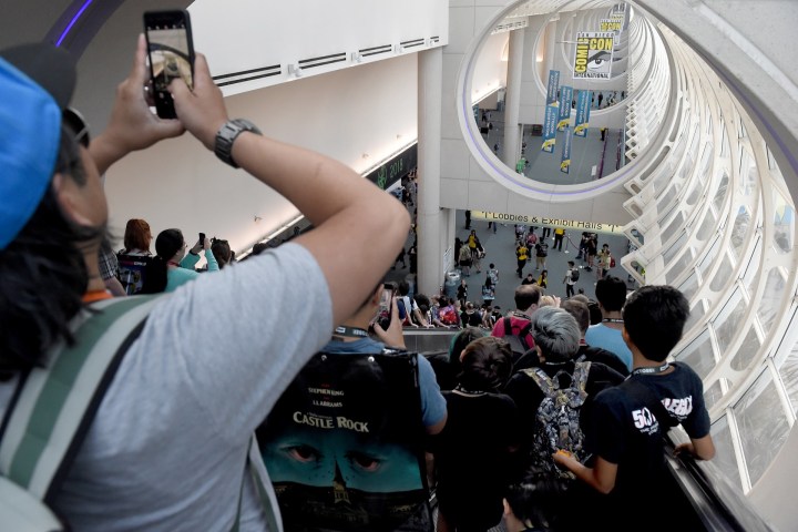A man takes a photo inside San Diego-Comic-Con.