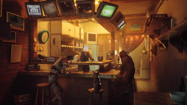 A cat sits at a bar with androids in Stray.