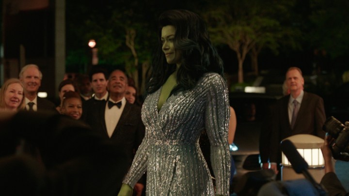 Tatiana Maslany as She-Hulk walks through a party in an elegant dress.