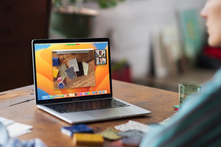 Un MacBook Pro M2 est posé sur une table en bois avec un joli fond bokeh.