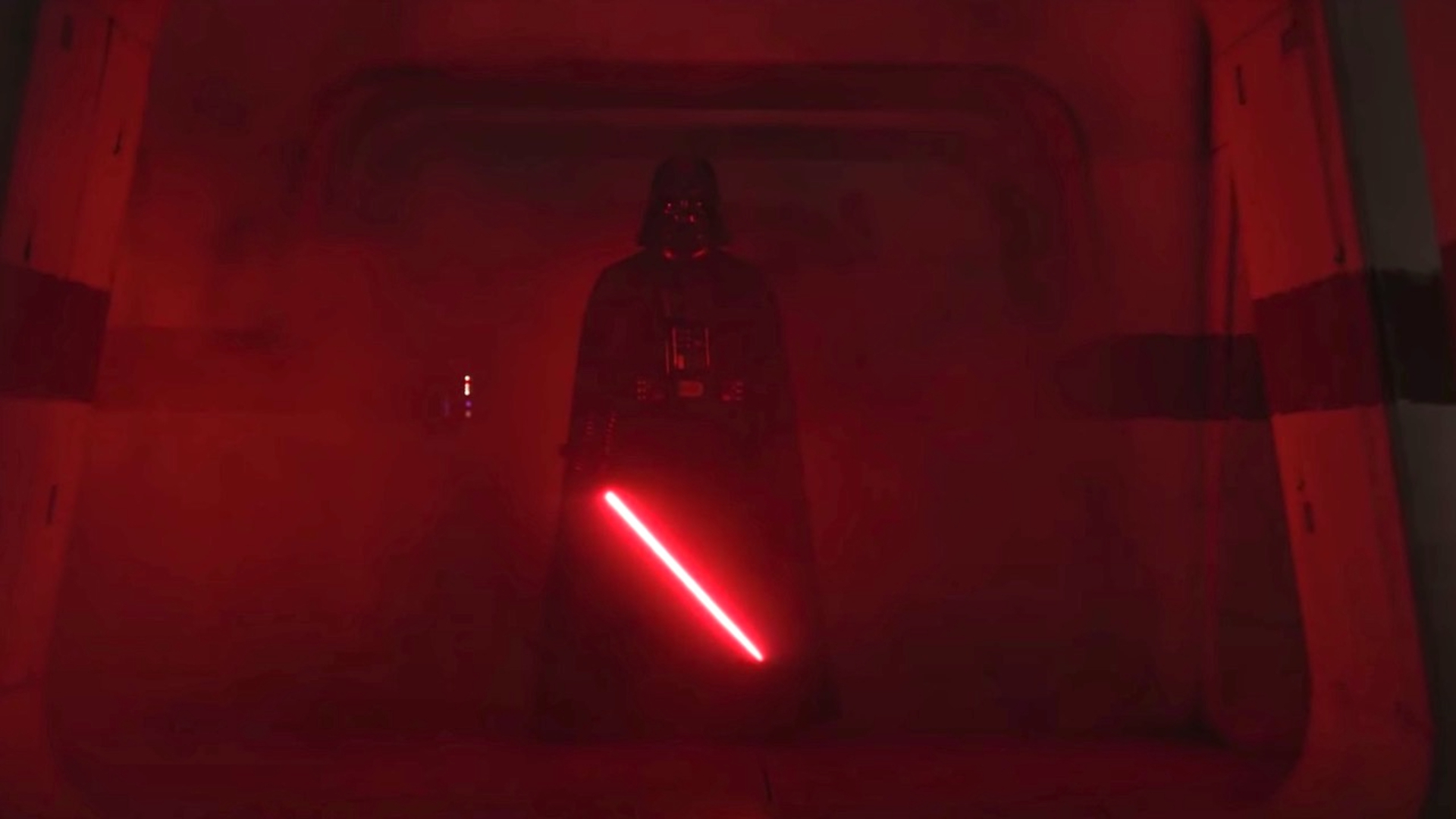 Darth Vader acendendo seu sabre de luz e iluminando o salão de vermelho em Rogue One.