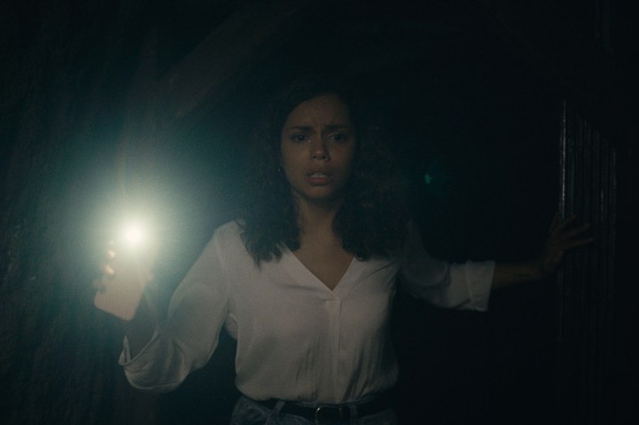 Georgina Campbell holds up her phone in a dark tunnel in Barbarian.
