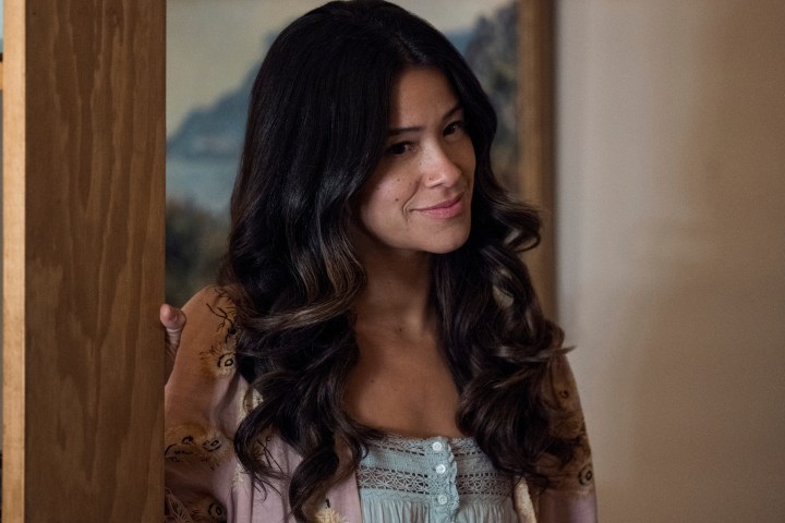 Gina Rodriguez leans against a wooden wall in Netflix's Lost Ollie.