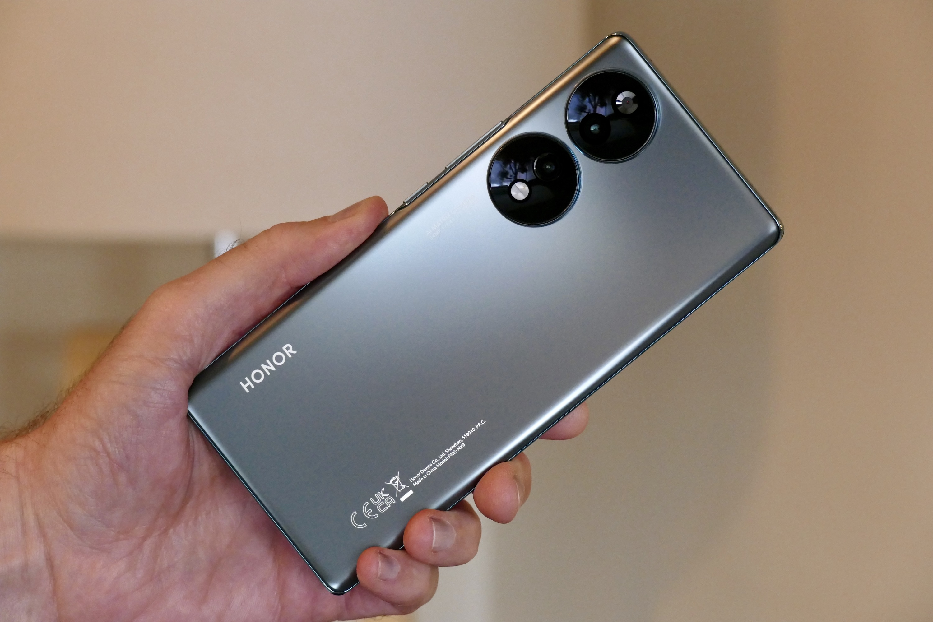 Honor 70 seen from the back and held in a mans hand.