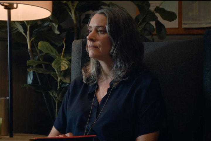 Paget Brewster sitting down and listening in a scene from Hypochondriac.