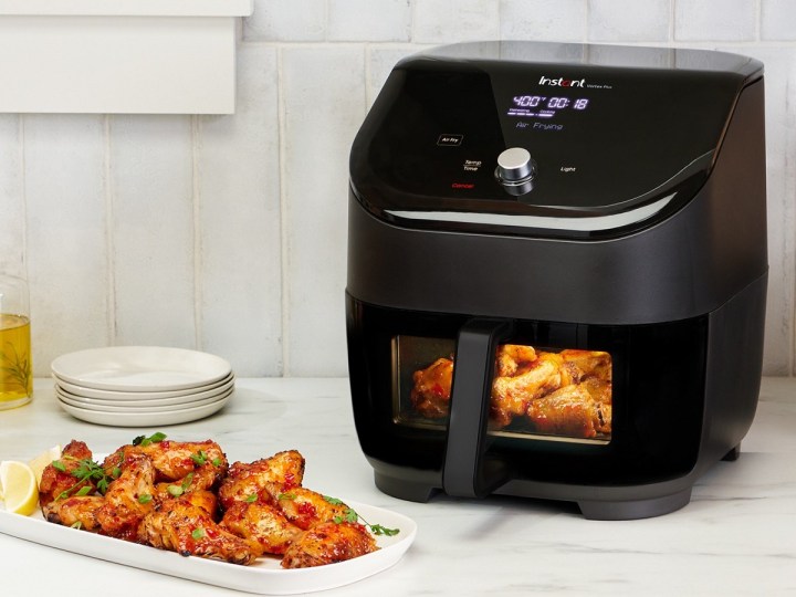 The Instant Pot Vortex air fryer with cooked chicken inside.