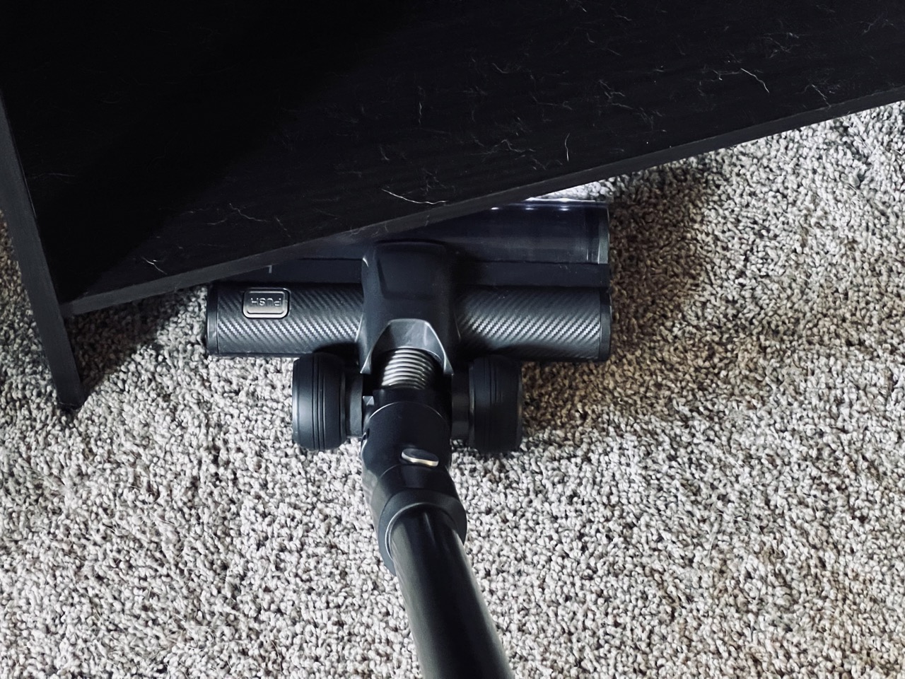 The Levoit VortexIQ 40 cleaning underneath some furniture.