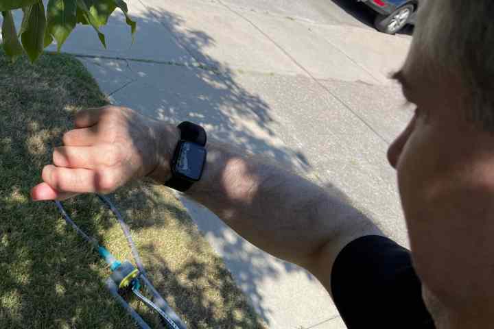 Persona che tiene in mano Apple Watch con Wristcam per la videochiamata.