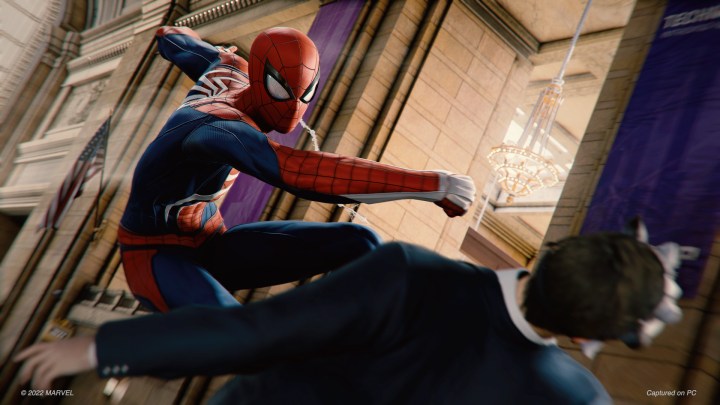 Spider-Man Remastered'da Spider-Man bir adamı yumrukluyor.