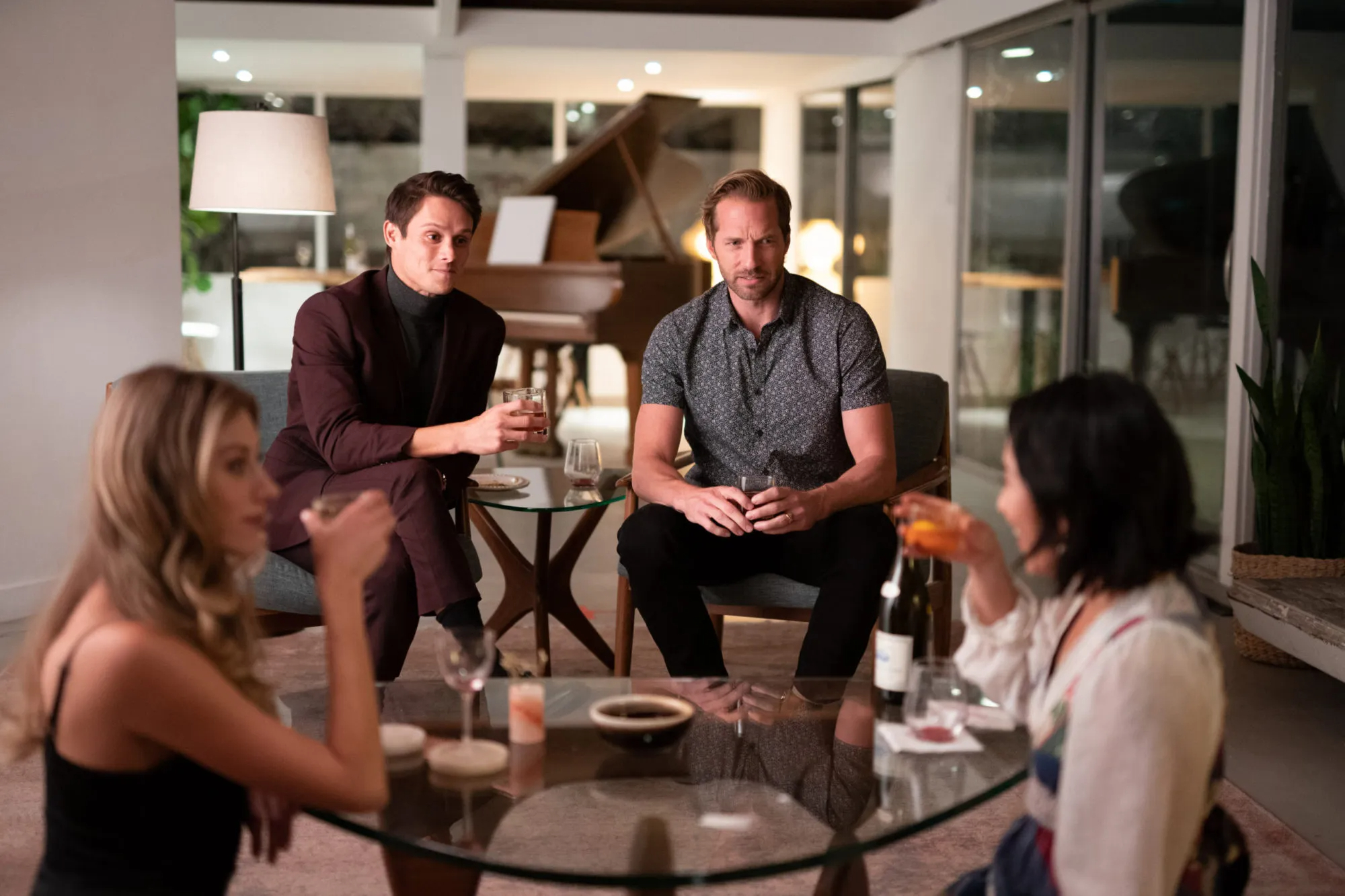 Sasha, Tom, Adam y Margo se sientan juntos alrededor de una mesa en Quién los invitó.