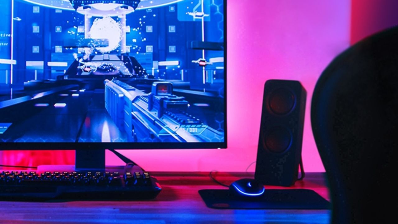 Luces TP-Link de color rosa brillante detrás de un monitor de computadora.