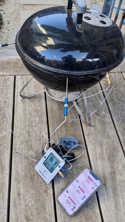 ThermoPro TP25 app and thermometer on a deck by a Hibachi grill.