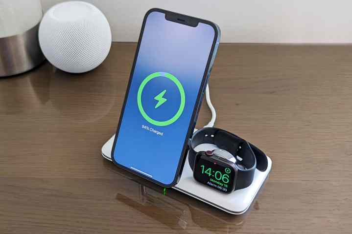 iPhone 12 Pro Max and Apple Watch Series 5 charging on Ugreen 3-in-1 MagSafe charging stand with HomePod mini in the background.