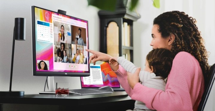 Woman and baby participate in a video call using the Dell 27 Video conferencing monitor.