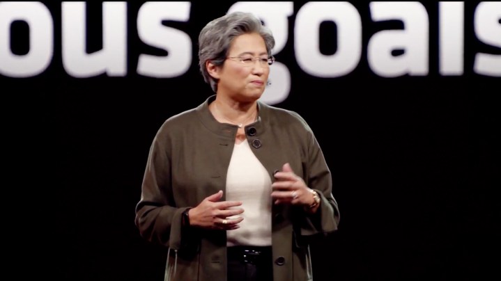 Dr. Lisa Su in a brown sweater stands on the AMD stage