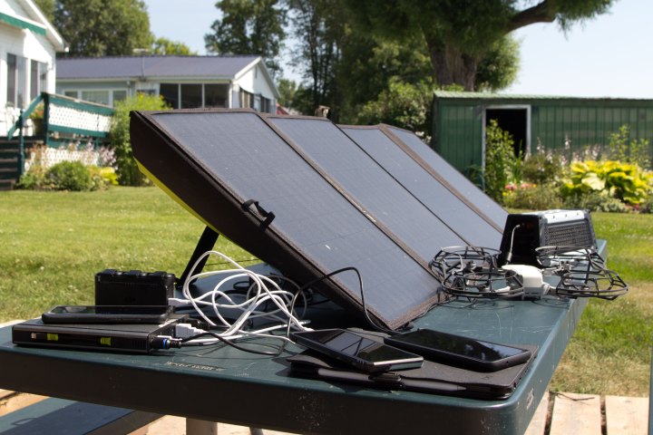 Goal Zero Nomad 100 solar panels on picnic table, charging devices. 