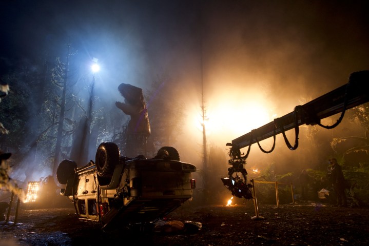 A Giganotosaurus model looms in the background of a scene being filmed for Jurassic World Dominion.