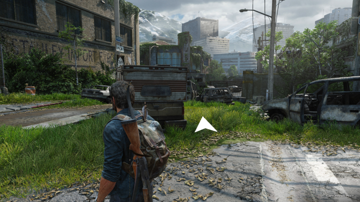 A white arrow shows Joel where to go in The Last of Us Part I.