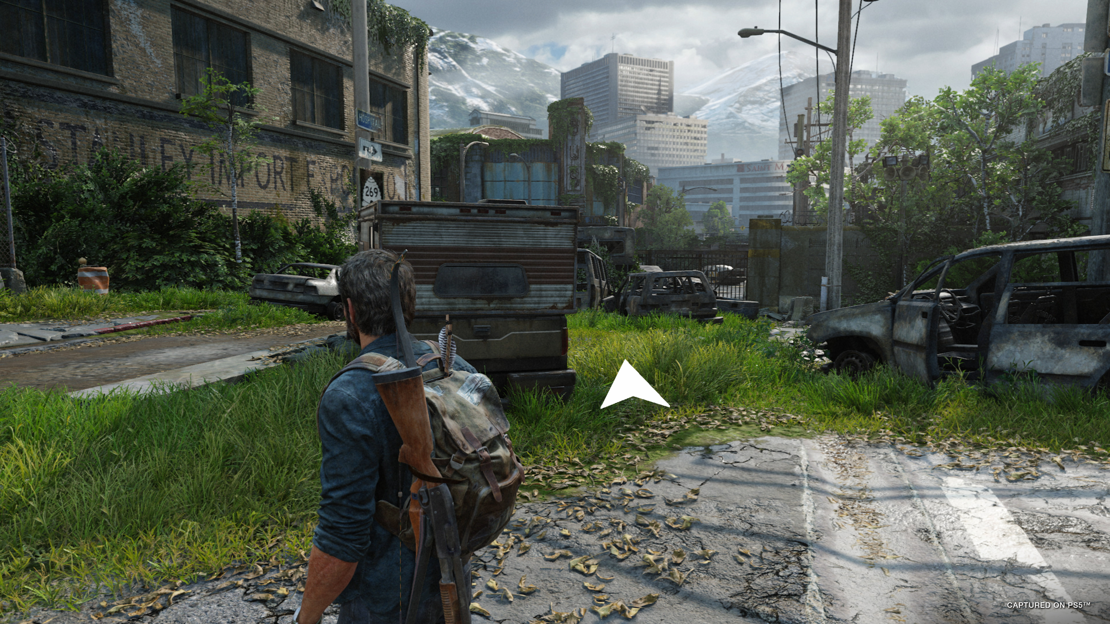 Uma seta branca mostra Joel para onde ir em The Last of Us Part I.