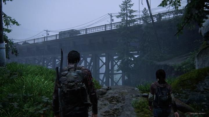 Joel and Ellie look at a bridge in The Last of Us Part I.