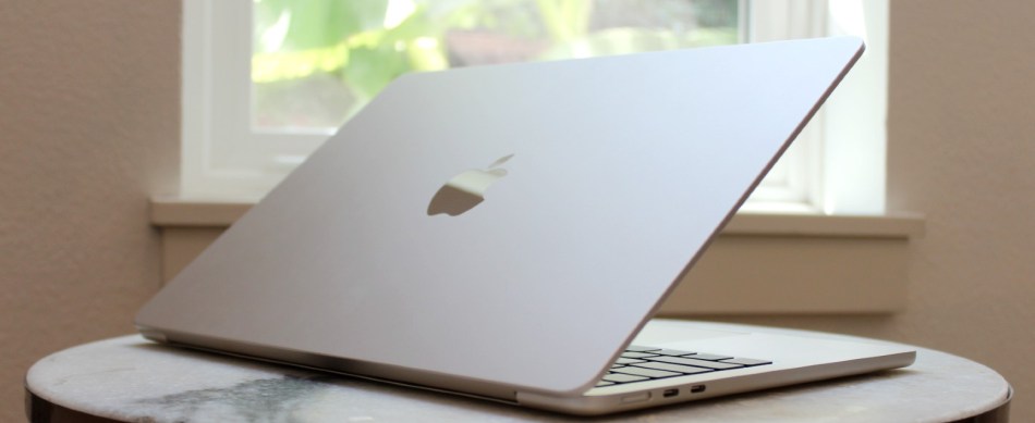 The MacBook Air on a table in front of a window.