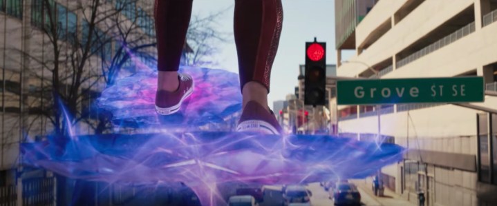 सुश्री मार्वल एक ट्रैफिक लाइट के सामने ऊर्जा के एक मंच पर खड़े होकर अपना पैर थपथपाती हैं।