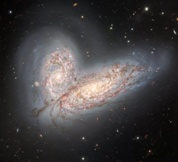 Apair of interacting spiral galaxies — NGC 4568 (bottom) and NGC 4567 (top) — as they begin to clash and merge. 