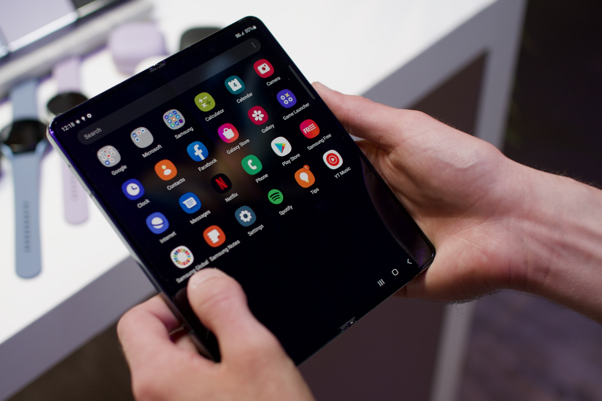 Someone holding the Samsung Galaxy Z Fold 4 while it displays its home screen.