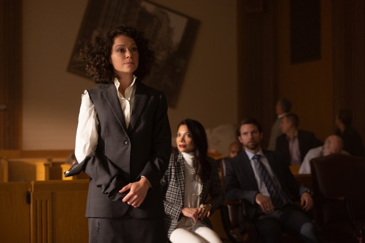 Tatiana Maslany stands in a courtroom in a torn suit in a scene from She-Hulk.
