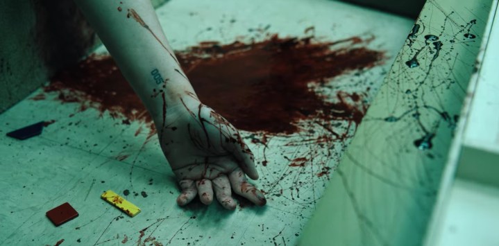 A bloody arm lies limp in a scene from Stranger Things season 4.