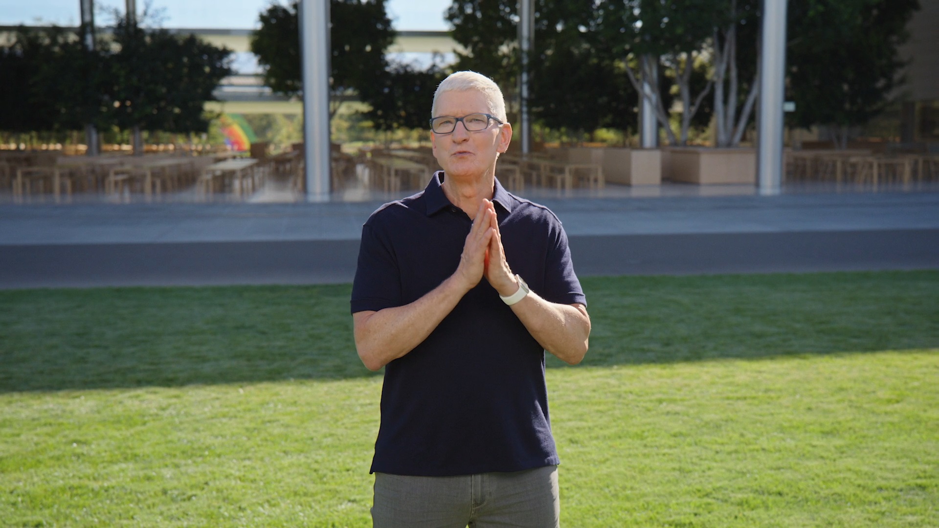 Tim Cook durante uma apresentação da Apple em um campo gramado.