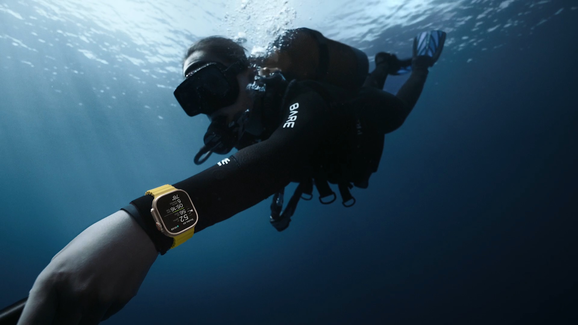 Uma pessoa usando o Apple Watch Ultra enquanto mergulha debaixo d'água.