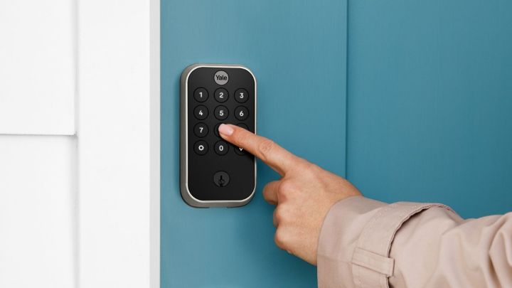 A person pressing a button on the Assure Lock 2.