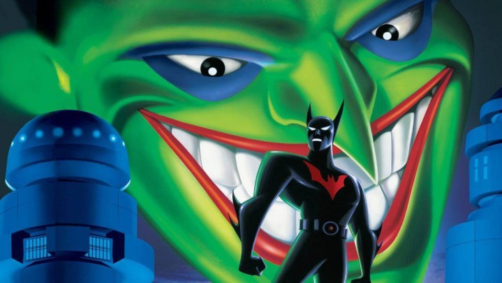 Batman standing on top of a building with the cityscape and Joker looming above.