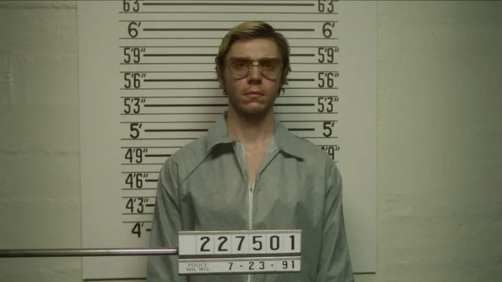 Evan Peters frente a una fila de policías en una escena de Dahmer.