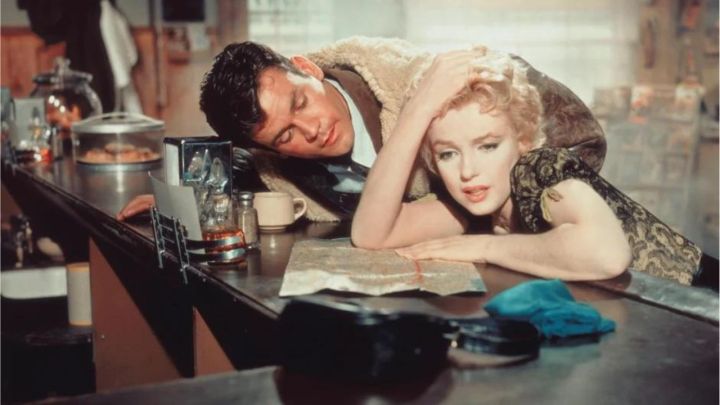 A young man and a distressed-looking woman leaning on a counter at a bar in the film Bus Stop.