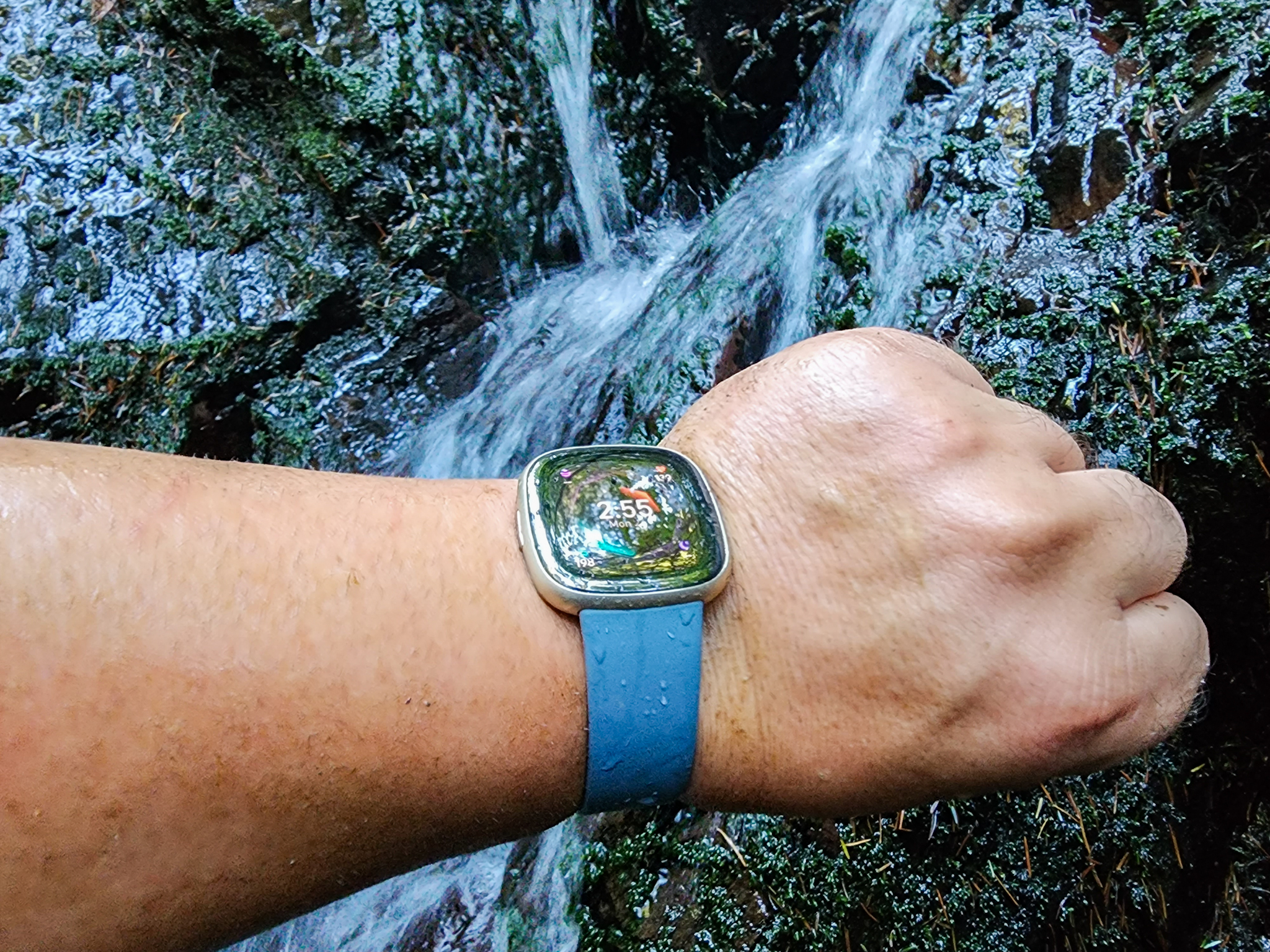 Vestindo o Fitbit Sense 2 ao lado de uma cachoeira.