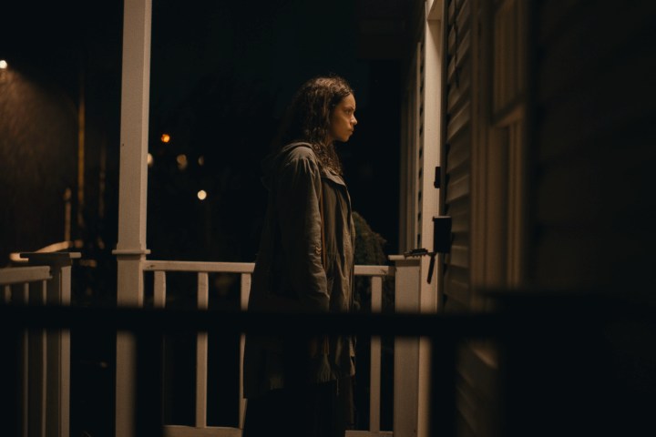 Georgina Campbell stands on a front porch at night in Barbarian.