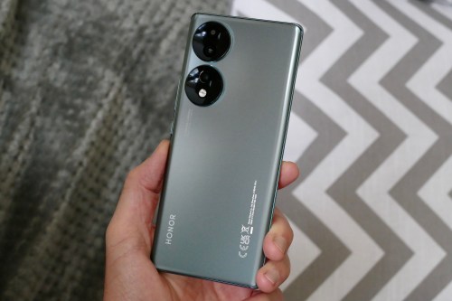 The Honor 70 held in a mans hand, seen from the back.
