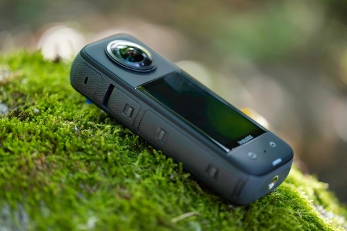 The Insta360 X3 on a moss covered rock.