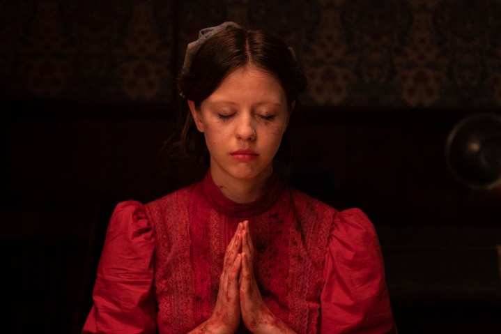 Mia Goth mantém as mãos juntas em posição de oração no Pearl da A24.