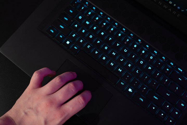 A hand using the trackpad on the Alienware x17 R2.