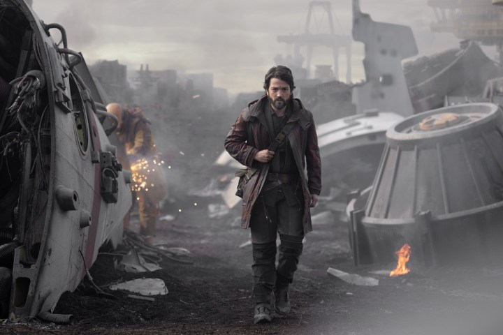 Diego Luna walks through a scrapyard of ships in a scene from Andor.
