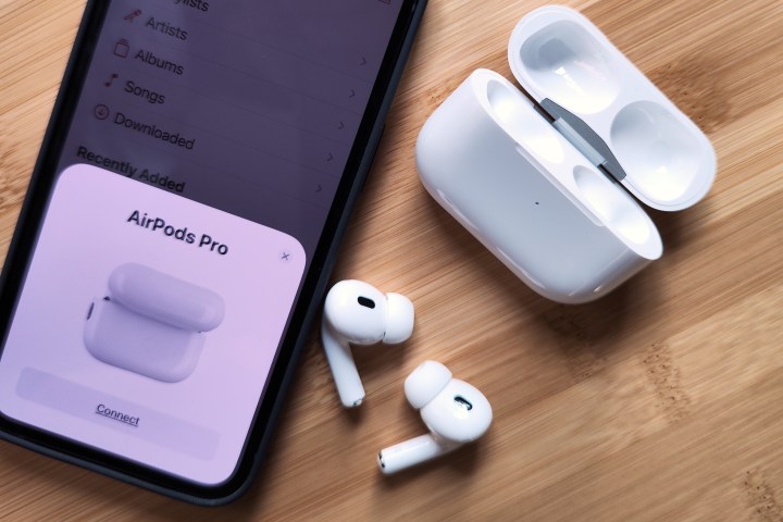 Apple AirPods Pro 2 junto al iPhone 14 y el estuche de carga.