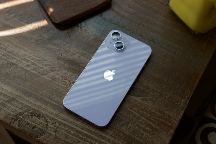 An iPhone 14 laying on a table.