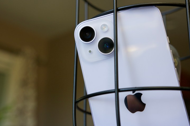 Un iPhone 14 appoggiato all'interno di una lampada decorativa.