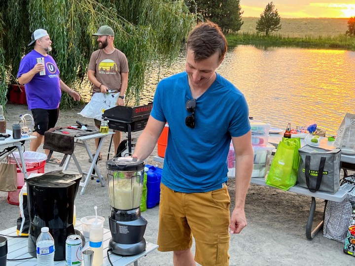 The author uses a blender to make mixed drinks at a campsite.