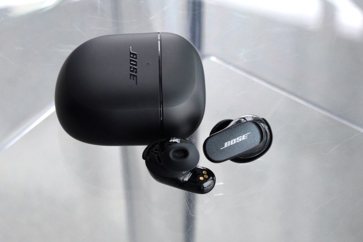 Bose QuietComfort Earbuds II در کنار جعبه شارژ.