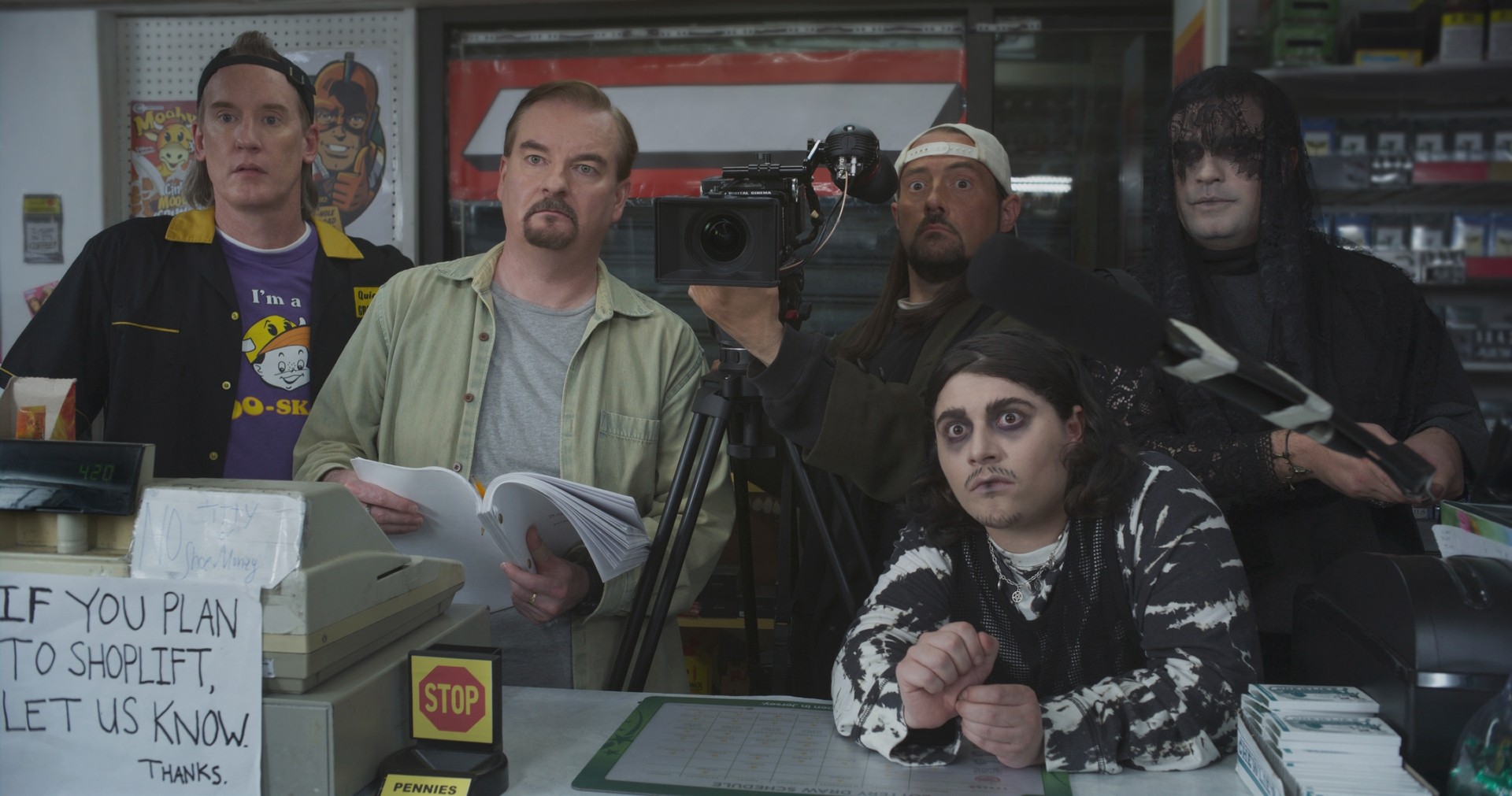 O elenco de Clerks III fica atrás de um balcão enquanto filma uma cena.